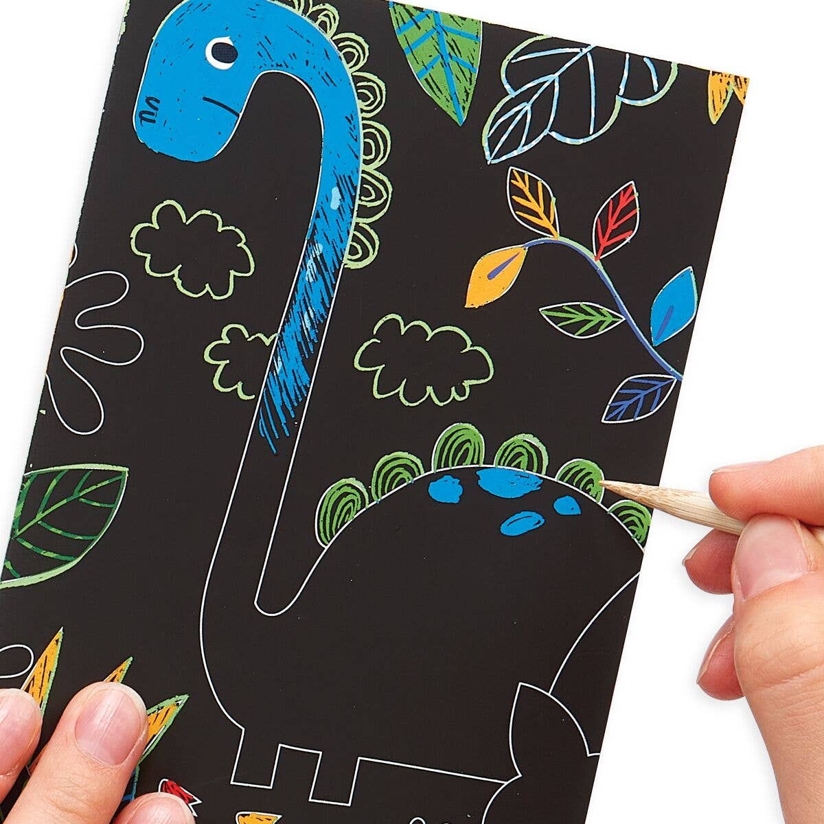 A close up of a person colouring in a picture of a dinosaur on a black piece of paper.