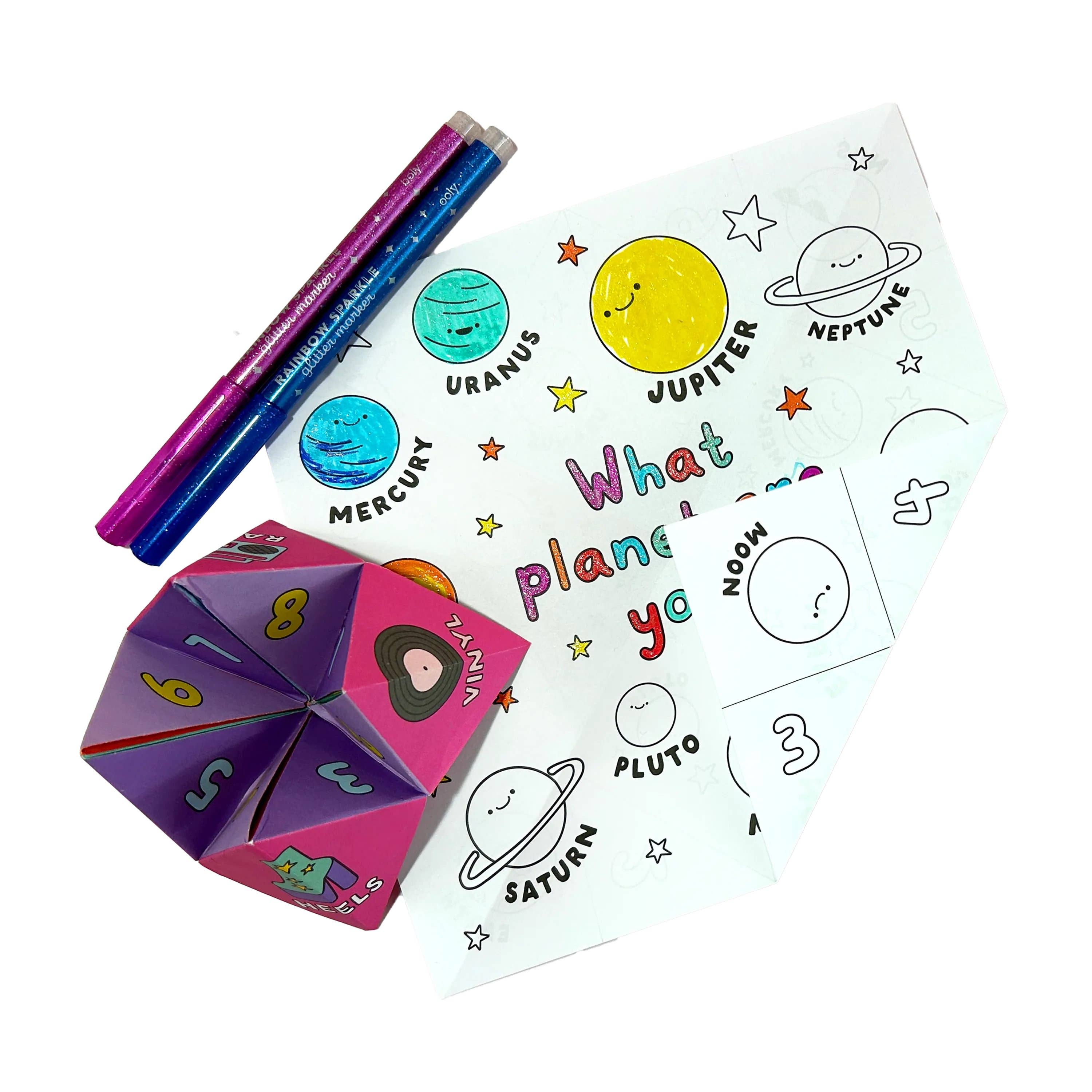 OOLY fortune teller and two pens next to a sheet of paper with all the planets on them.