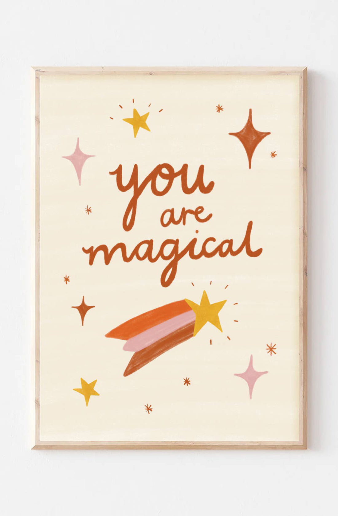 An art print set on a beige background, hand-illustrated type reads "You are Magical" surrounded by tiny sparkles and a shooting star by Laura Sissons Studio.