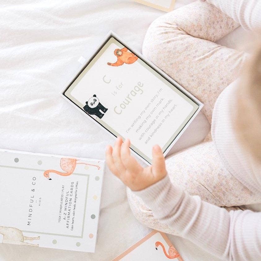 A young toddler playing with the mindful affirmation cards.