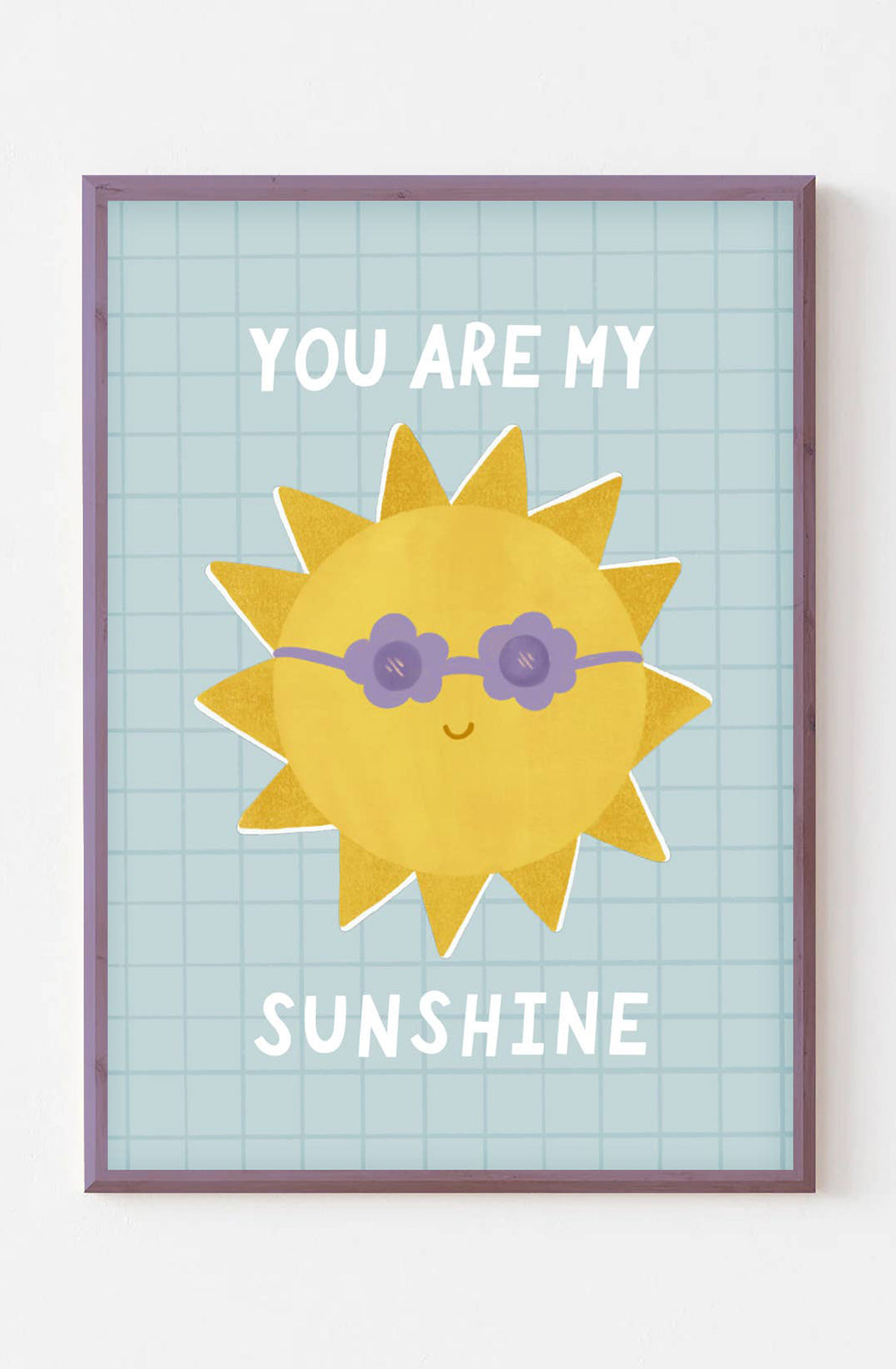 An art print with a picture of a sun wearing purple flower shaped sunglasses with the words "you are my" above it and the word "sunshine" below it. The print is on a blue background with a square pattern over the top. The art print is by Lauren Sissons Studio.