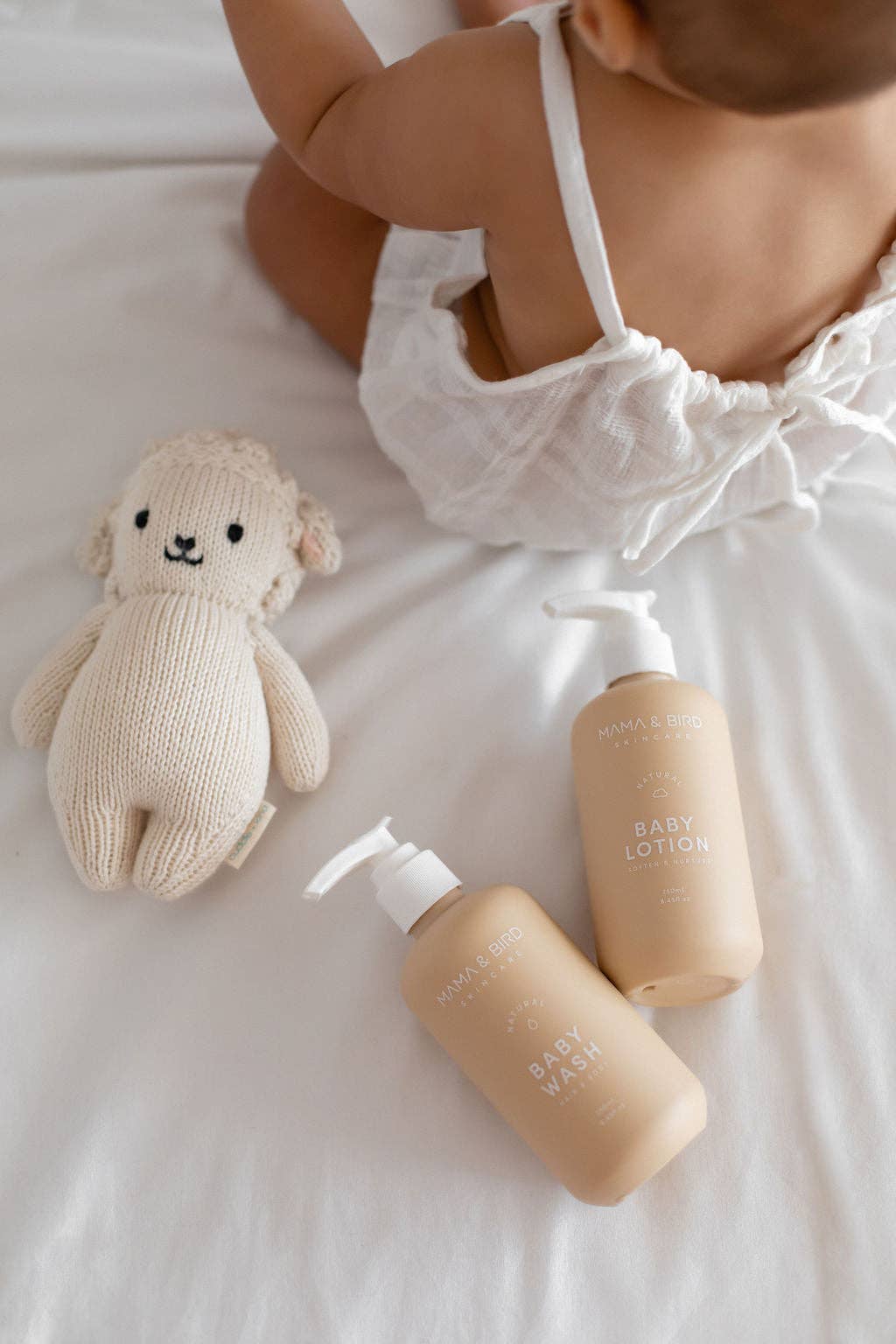 Mama and Bird baby wash and lotion bottles next to a toy and baby.