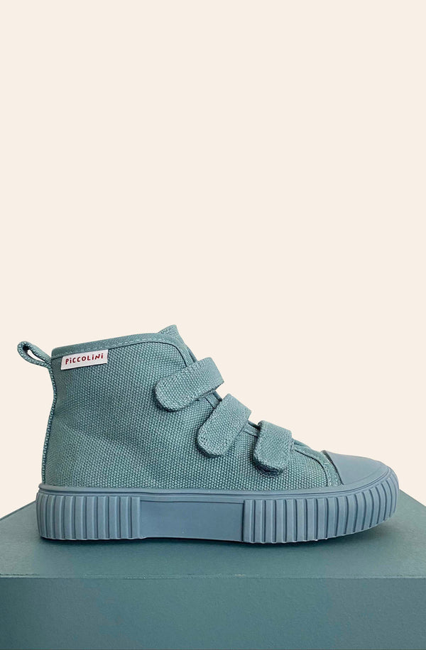 Side view of blue high top on blue block with white background