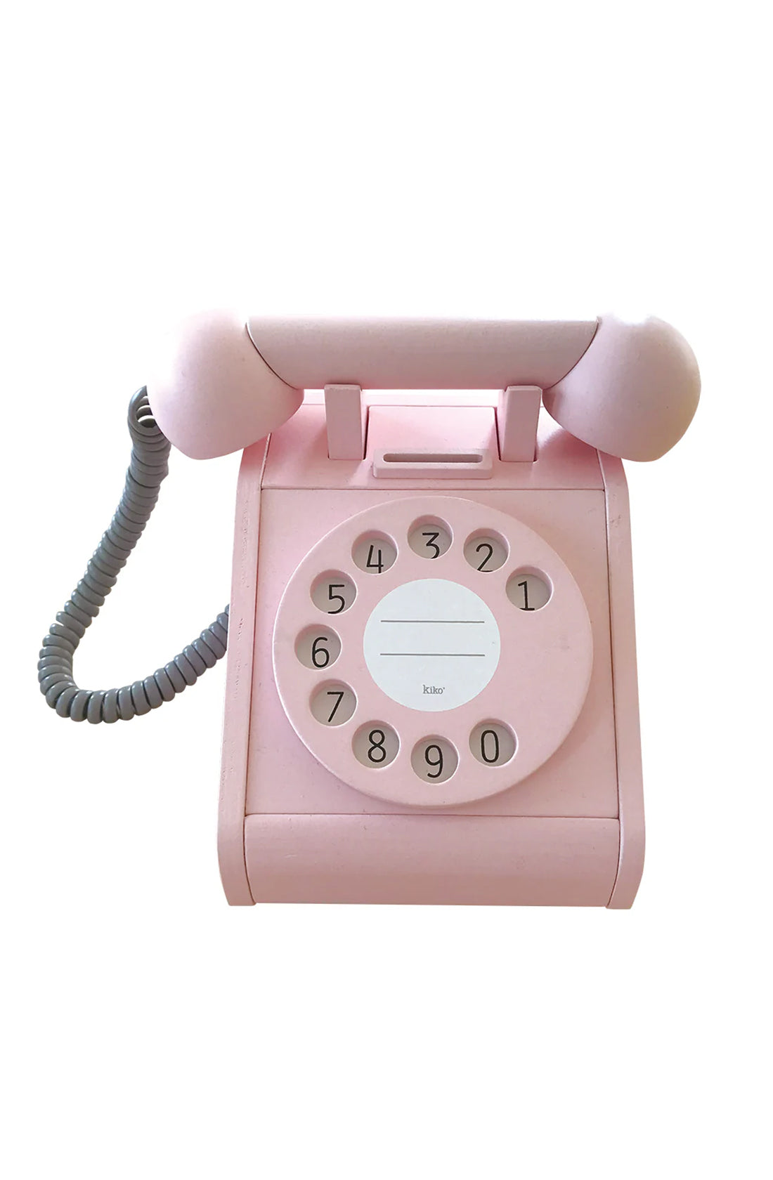 The Retro Telephone Pink by KIKO & GG is perfect for sparking children's imagination with its nostalgic design. This charming pink rotary dial telephone features a gray coiled cord and embodies a retro form with a circular dial displaying numbers 0 through 9, and a space in the center for labeling. The handset conveniently rests on top of the phone body, making it as functional as it is delightful.