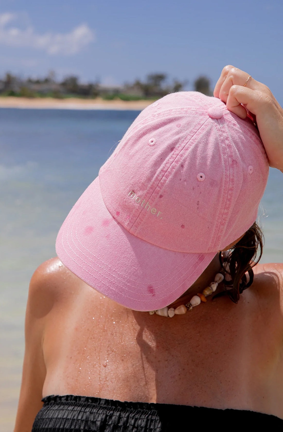 a women wearing a pink hat with the word mother on it.