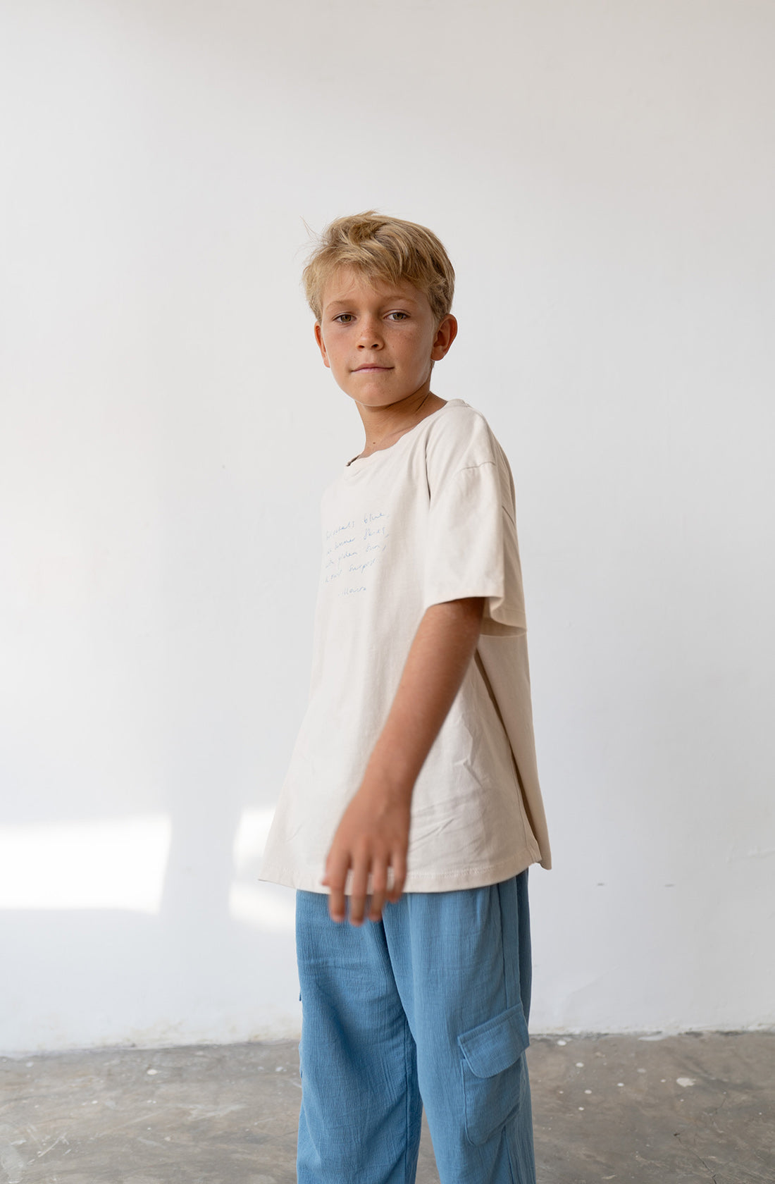 Young boy wearing the poet tee undyed and the henna cornflower pants.