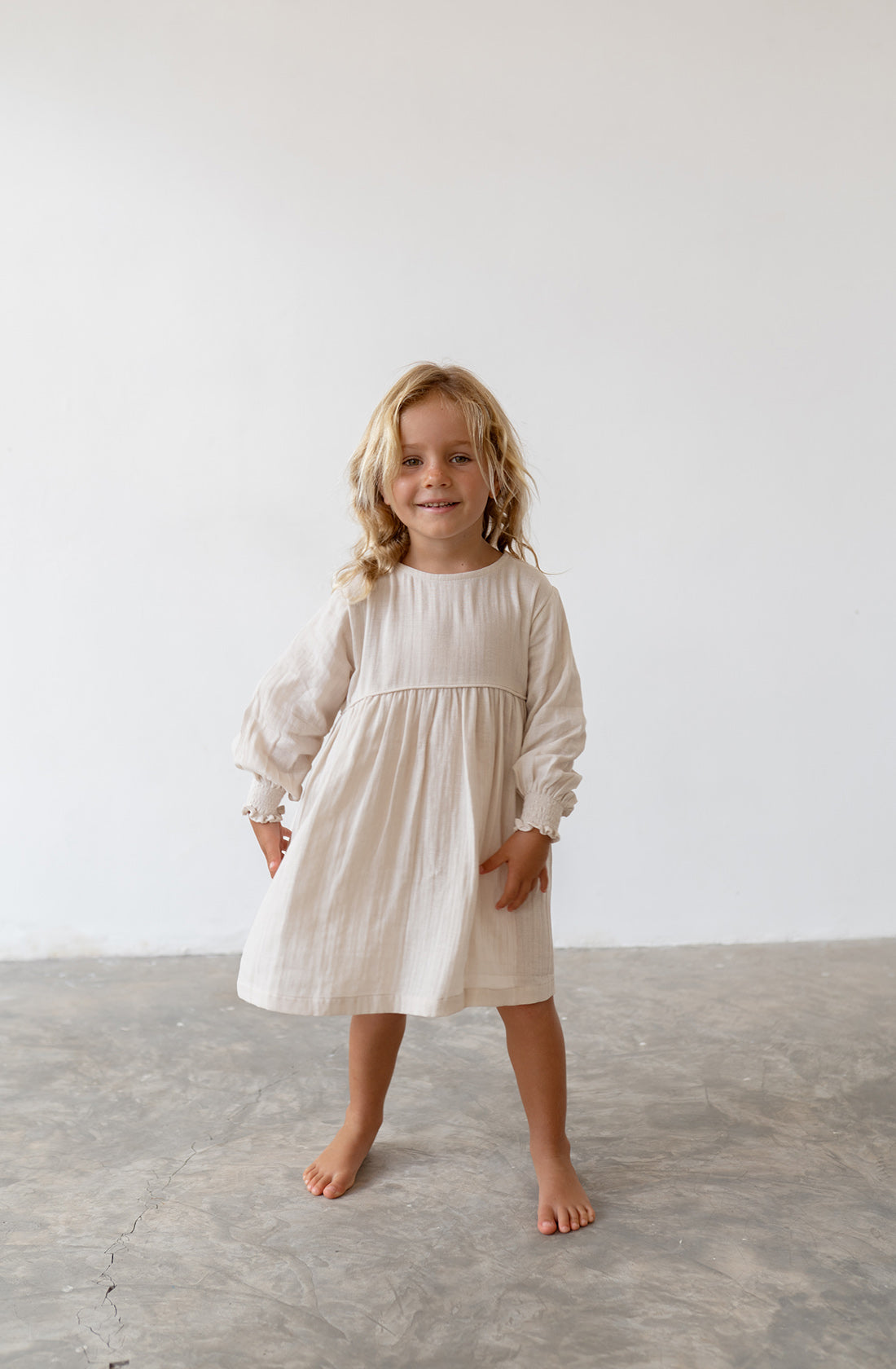 Young girl wearing the yumi dress in natural.