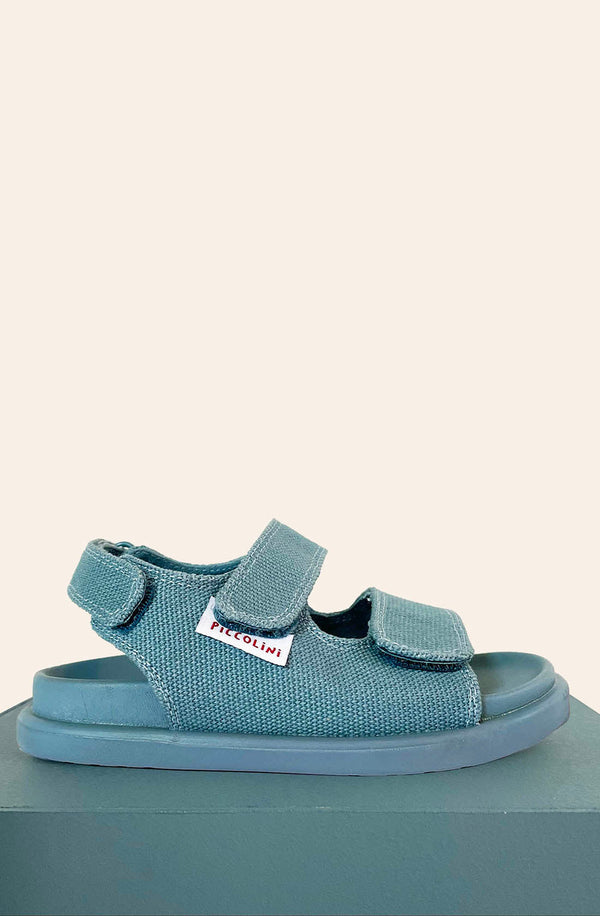 Side view of blue sandal on blue block and white background