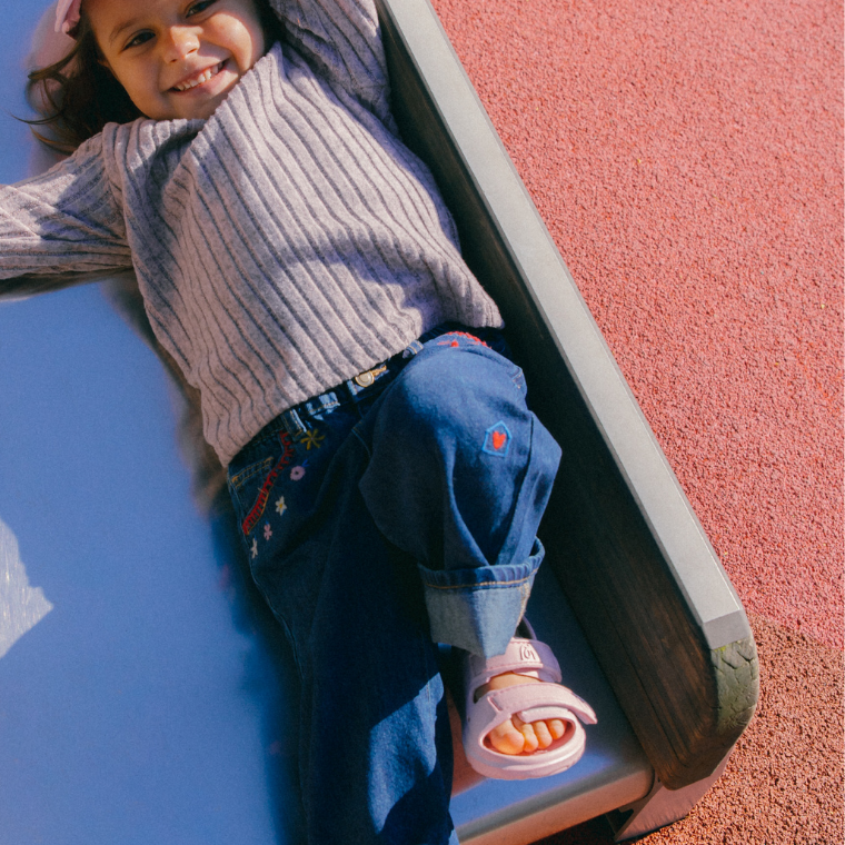 Child on a slide wearing Simples WonderSkips sandals in Petal Pink