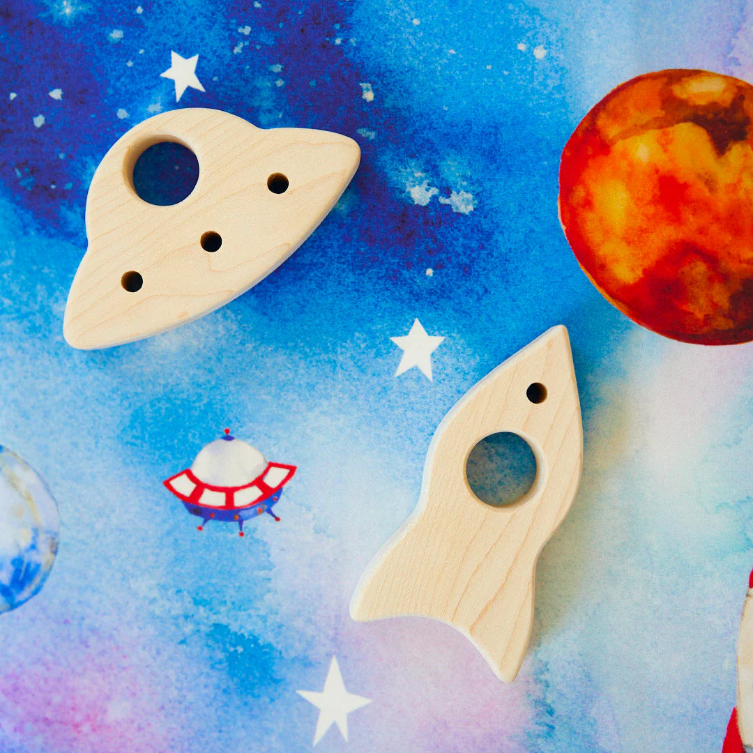 The Outer Space Seek & Find Playsilk by SARAH'S SILKS allows the wooden toy spaceship and rocket to soar across a vibrant space-themed setting, featuring stars and planets for imaginative adventures. Ideal for open-ended play, it inspires young explorers to dream among the cosmos.