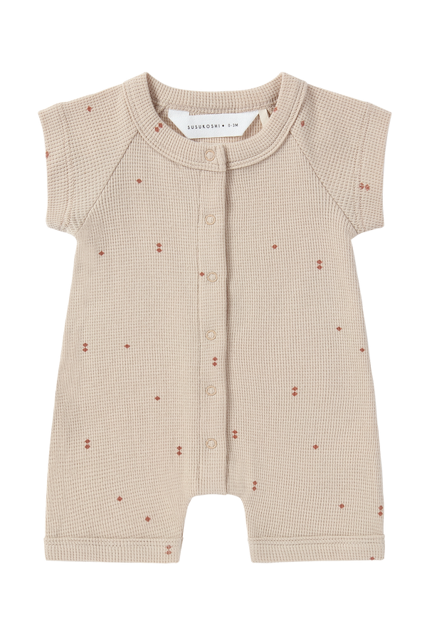 Front view of waffle romper in a subtle diamond print with snaps down the front