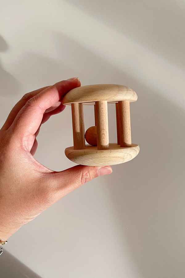 Hand holding the wooden rattle