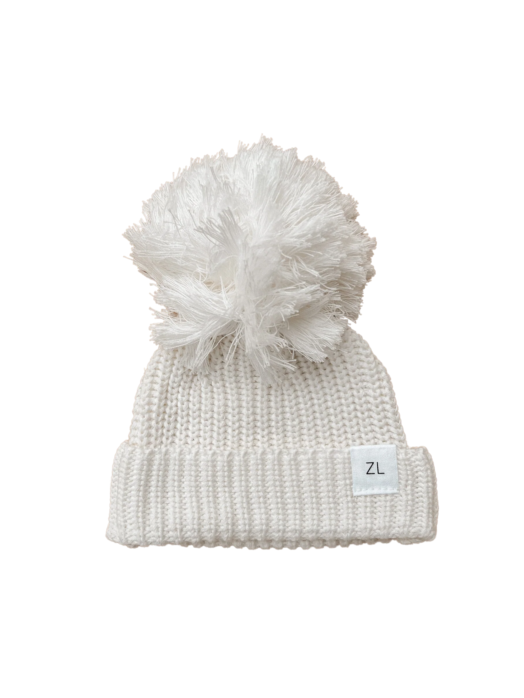 The Ziggy Lou - Beanie Milk by ZIGGY LOU is a chunky knit beanie made from 100% cotton, featuring a large fluffy pom-pom, a folded brim with a "ZL" tag, all set against a bold black background.