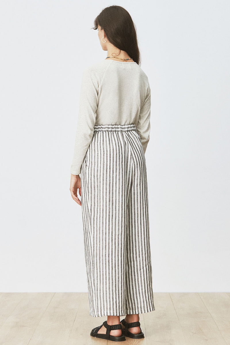 Rear view of woman wearing Cora Tee in Cream Marle with striped pants