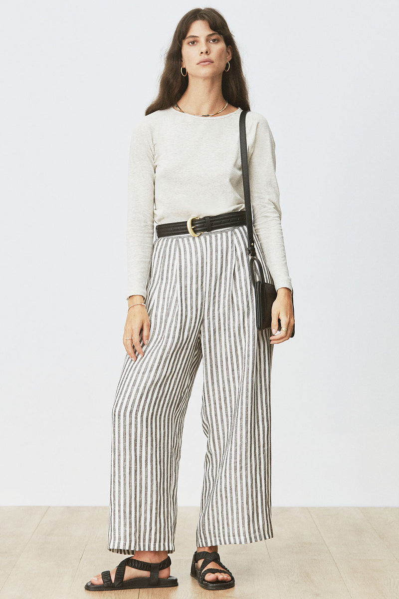 Woman wearing Cora Tee in Cream Marle with striped pants and black bag