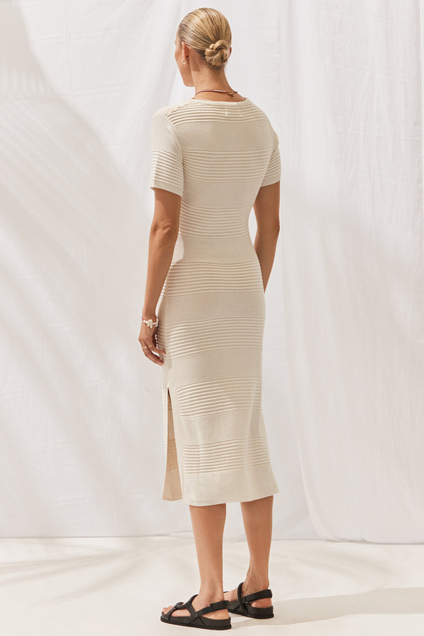 Woman wearing Isabella Dress in Off White. Full length, rear view.