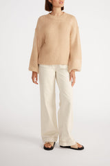 Woman wearing Ana Oversized Jumper with cream wide leg jeans.