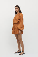 Side view of woman wearing Viviers Off Shoulder Top with matching shorts in marmalade.