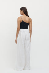 Rear view of woman wearing Sete Linen Elastic Waist Pant in white with an asymmetrical black top.