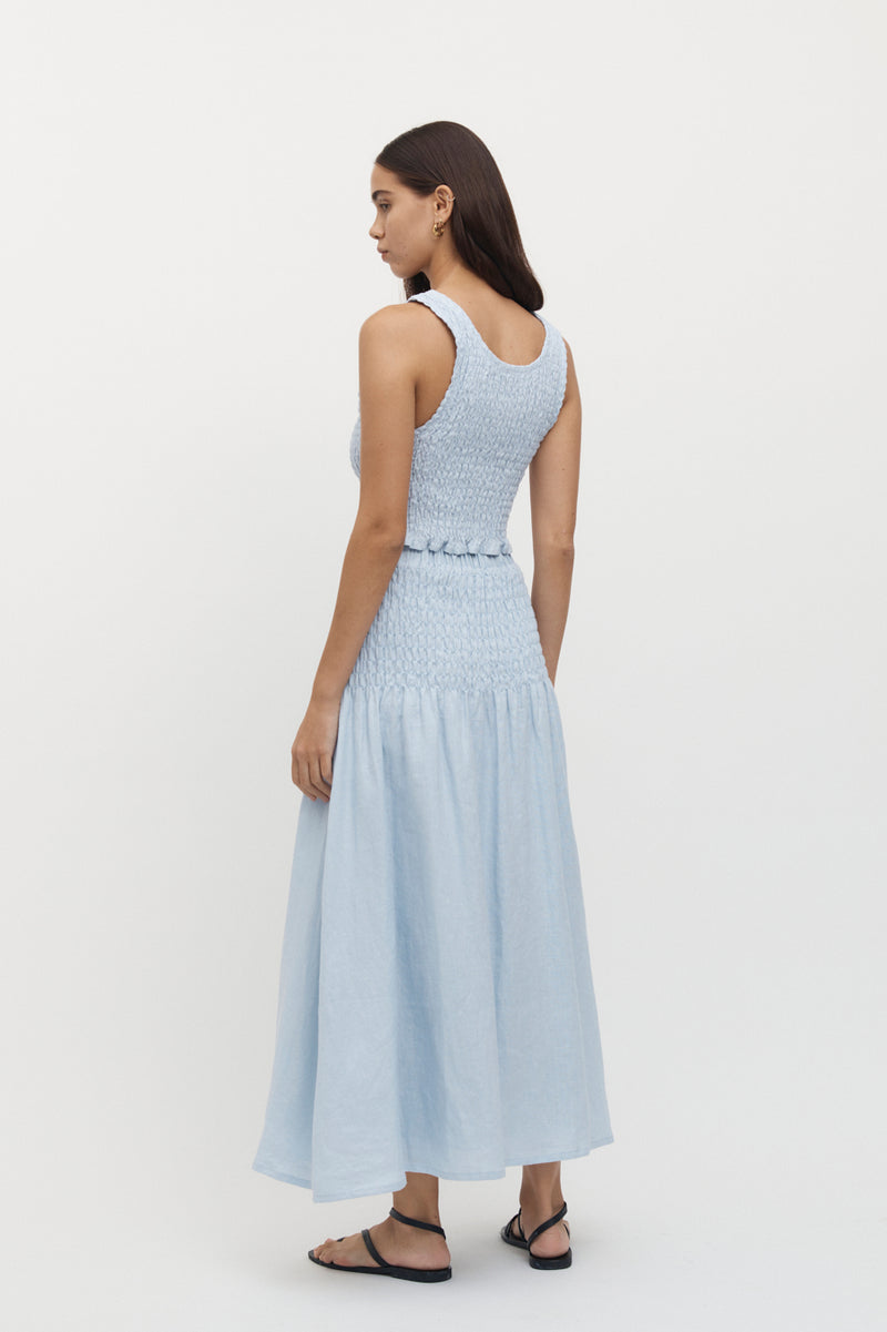 Rear view of woman wearing Eze Shirred Linen Midi Skirt in sky, with matching crop top.
