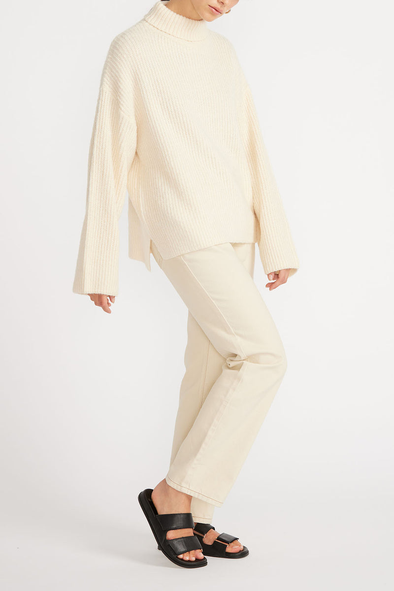Alternative view of woman wearing Esme Roll Neck Jumper in cream with cream jeans