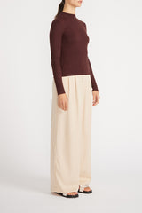 Side view of woman wearing Kaia Knit Skivvy with wide leg pants.