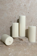 Group of various sized candles on travertine stack