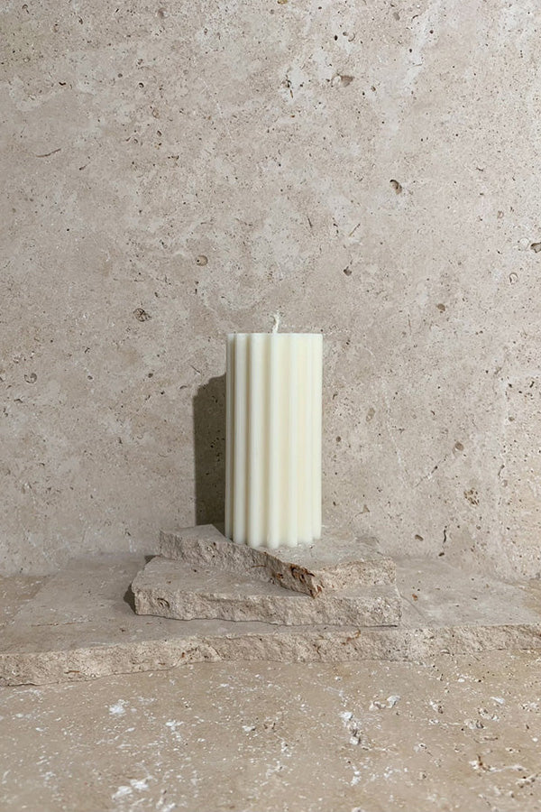 Wiggle pillar candle cream on travertine stack