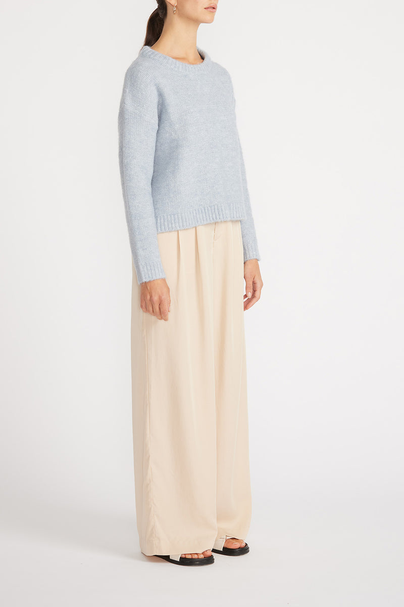 Side view of woman wearing Mika Jumper with wide leg pants.
