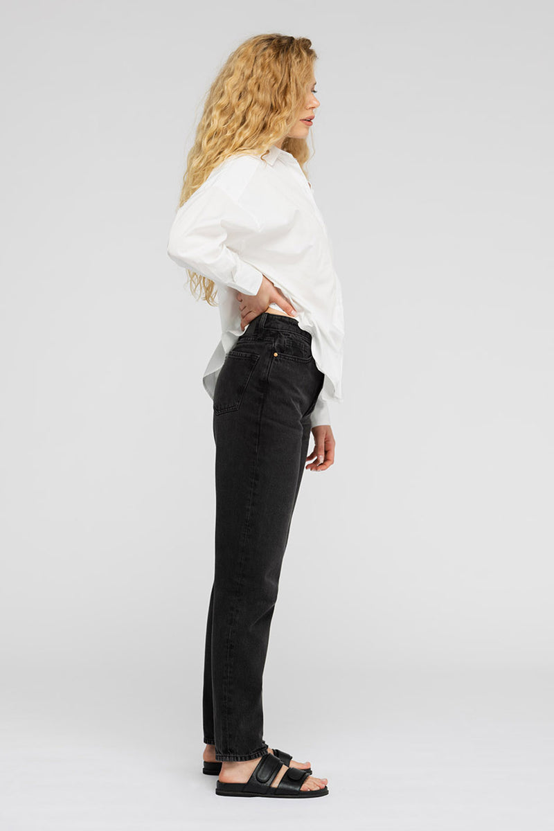 Side view of woman in white shirt and black jeans