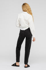 Rear view of woman in white shirt and black jeans